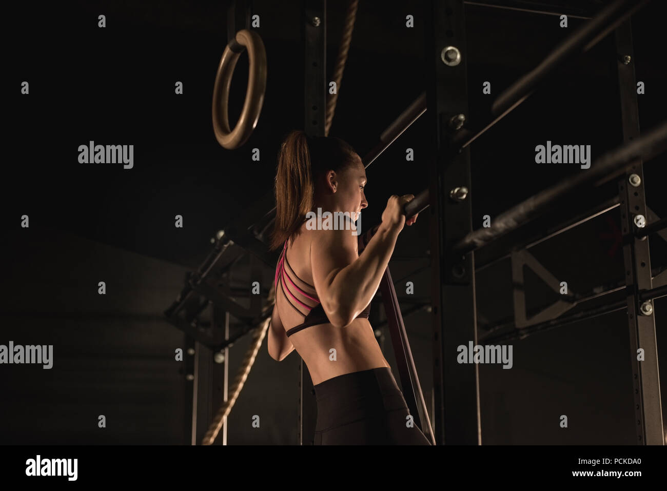 Woman doing pull-ups at the gym Stock Photo