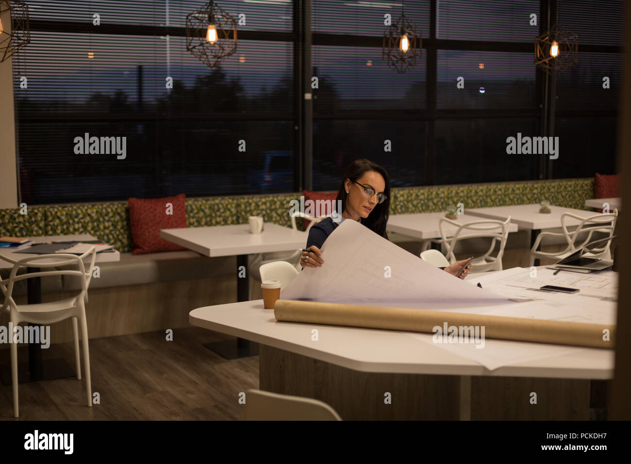 Female looking at blueprint Stock Photo - Alamy