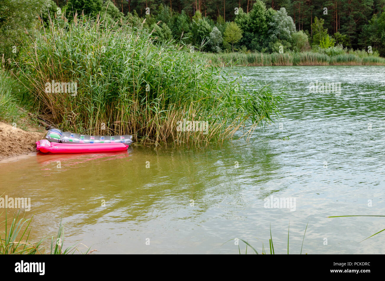 Lake beach with air mattresses. Nice landscape of german lake vacation