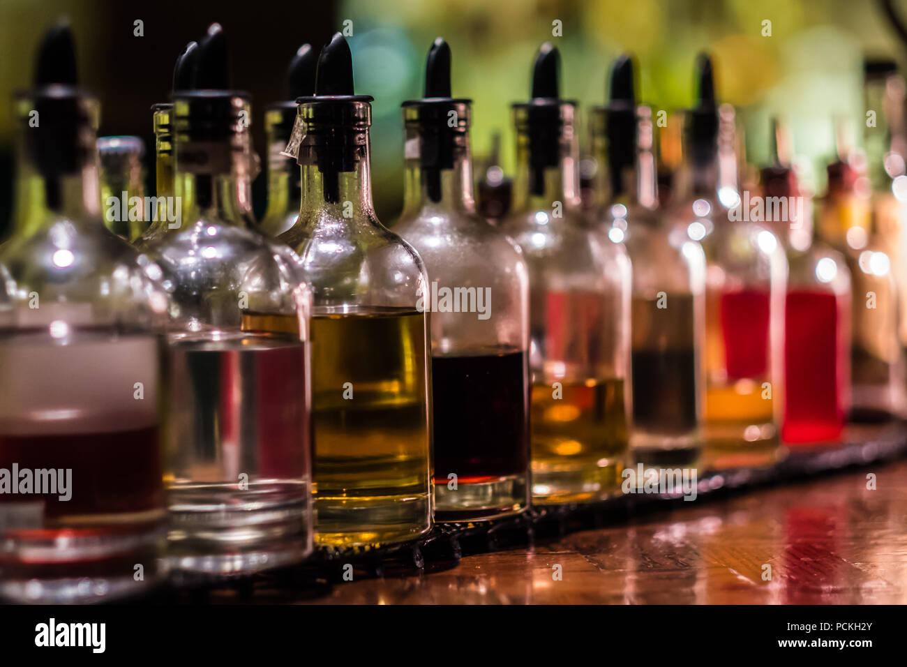Bottles with syrups for mixing cocktails on bar counter. Alcohol drinks