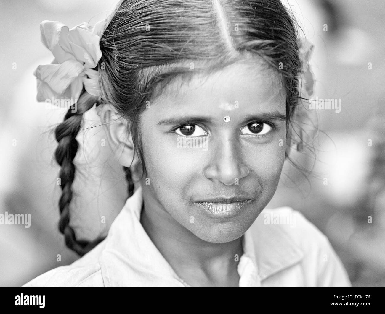 PONDICHERY, PUDUCHERRY, TAMIL NADU, INDIA - SEPTEMBER Circa, 2017. An unidentified poor girl in a small village, outdoor, looking at the camera. Black Stock Photo