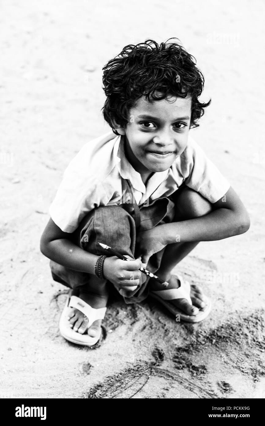PONDICHERY, PUDUCHERRY, TAMIL NADU, INDIA - SEPTEMBER CIRCA, 2017. Portrait of unidentified Indian poor kid boy is smiling outdoor in the street. Blac Stock Photo