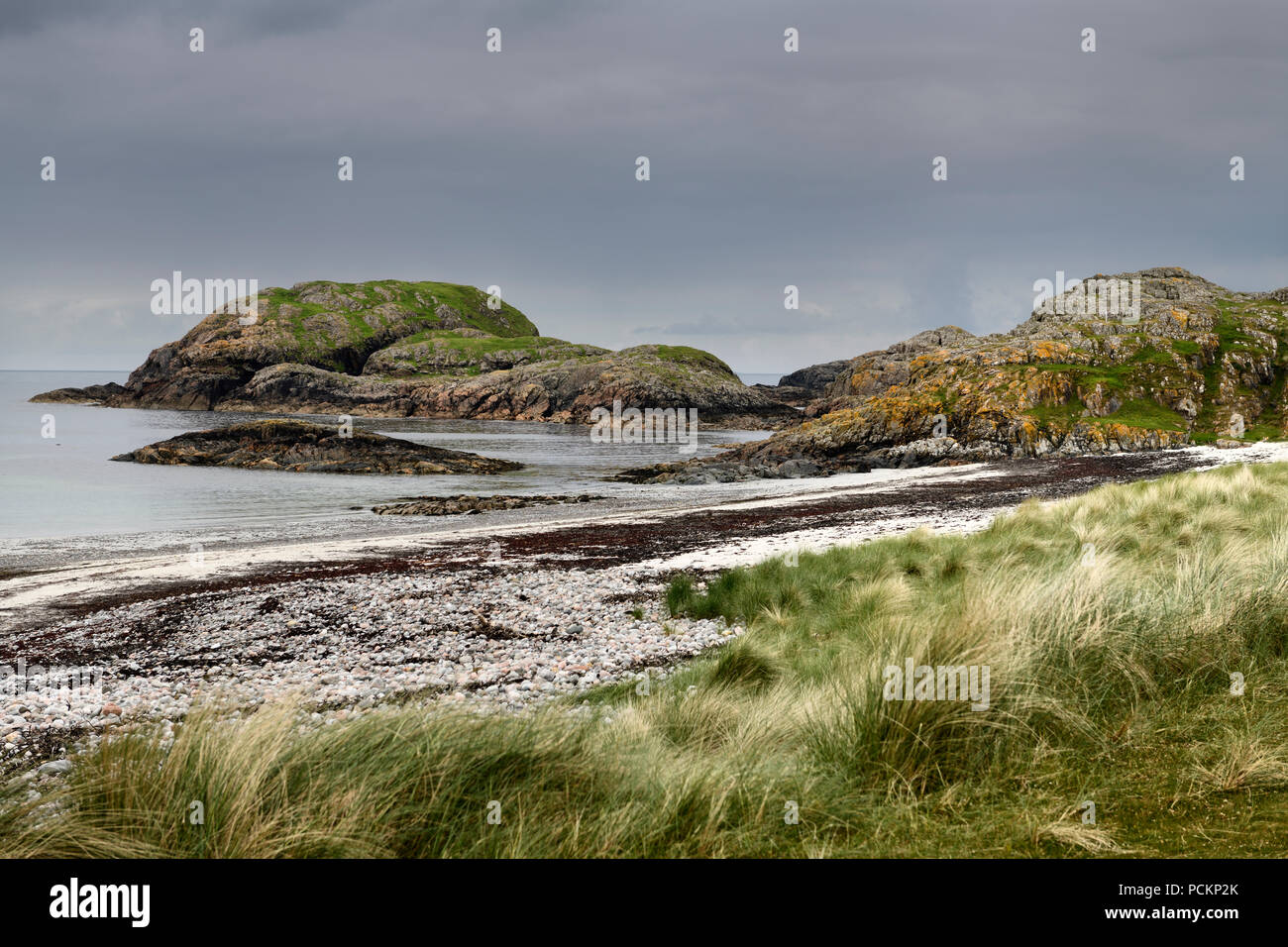 Seaside grass and granite outcropping on the shore of The Bay at the Back of the Ocean at The Machair on Isle of Iona Inner Hebrides Scotland UK Stock Photo