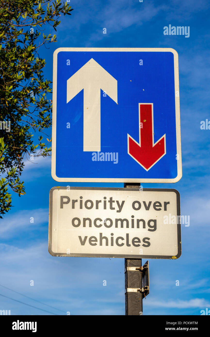 Priority over oncoming vehicles traffic sign against blue sky in England, UK Stock Photo