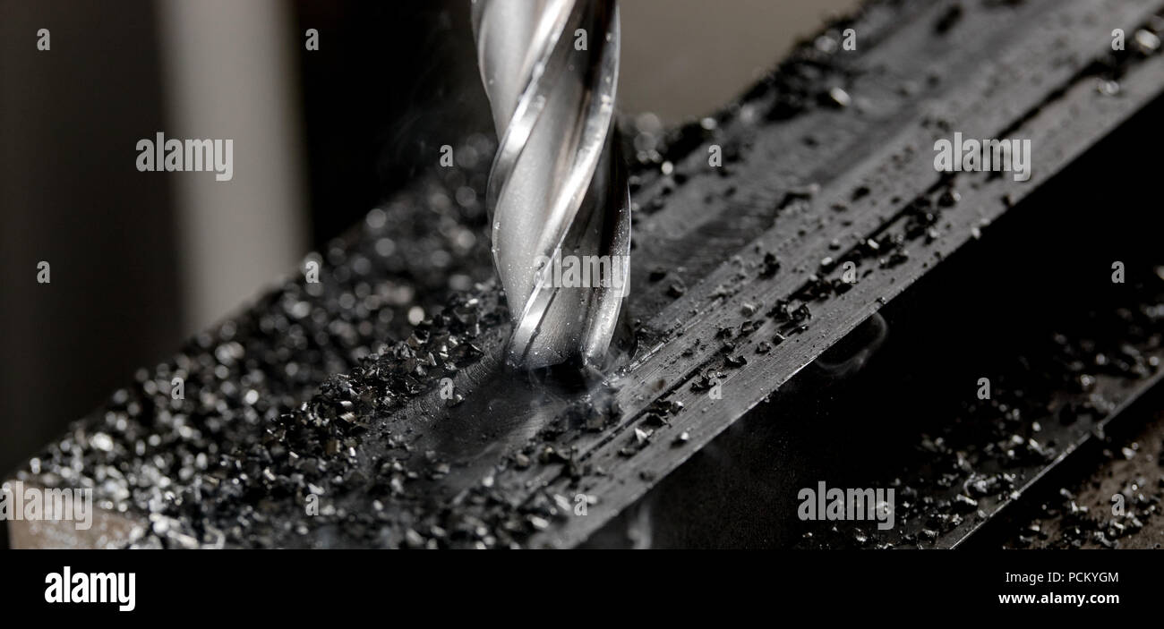 Bridgeport CNC end mill finishing a stack of steel plate with metal filings chips Stock Photo