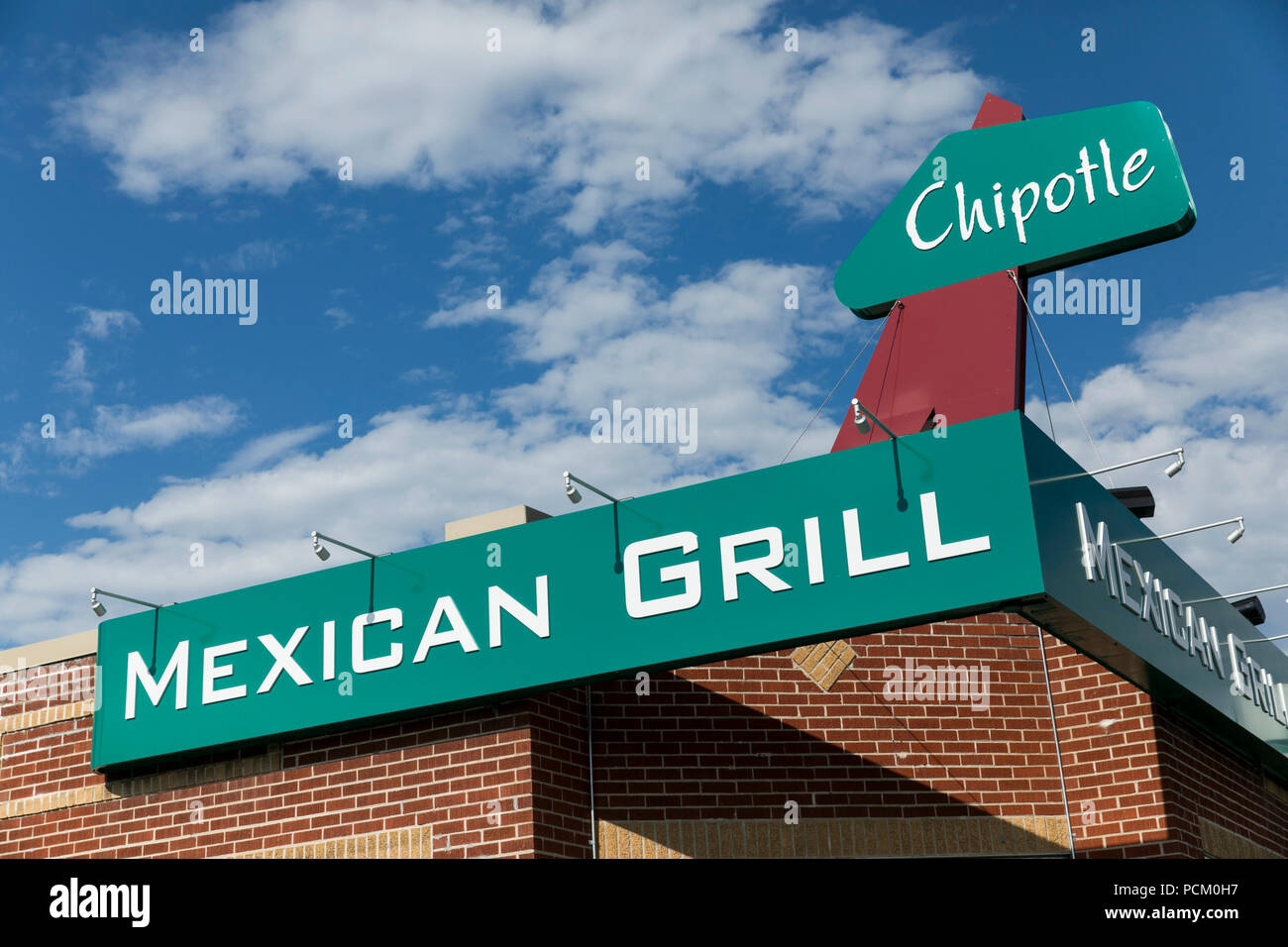 A logo sign outside of the first Chipotle fast casual restaurant location in Denver, Colorado