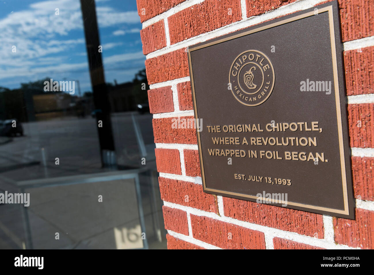 A logo sign outside of the first Chipotle fast casual restaurant