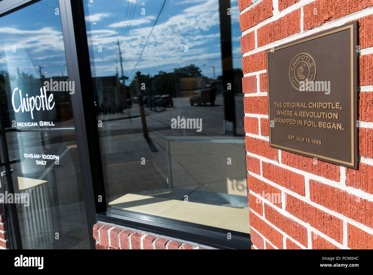 A logo sign outside of the first Chipotle fast casual restaurant