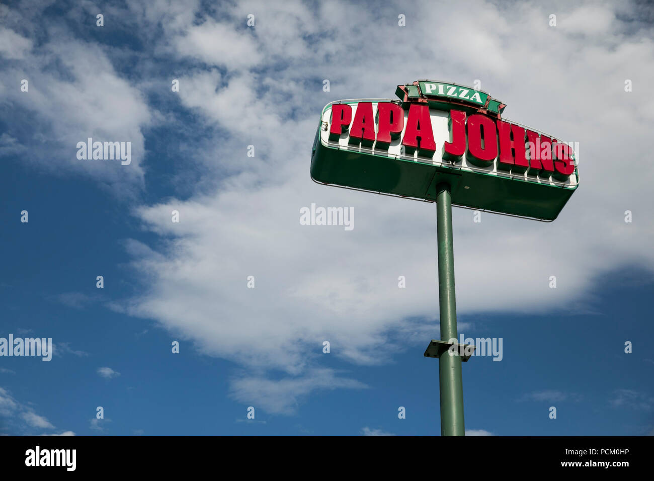 A logo sign outside of a Papa John's Pizza franchise location in Denver