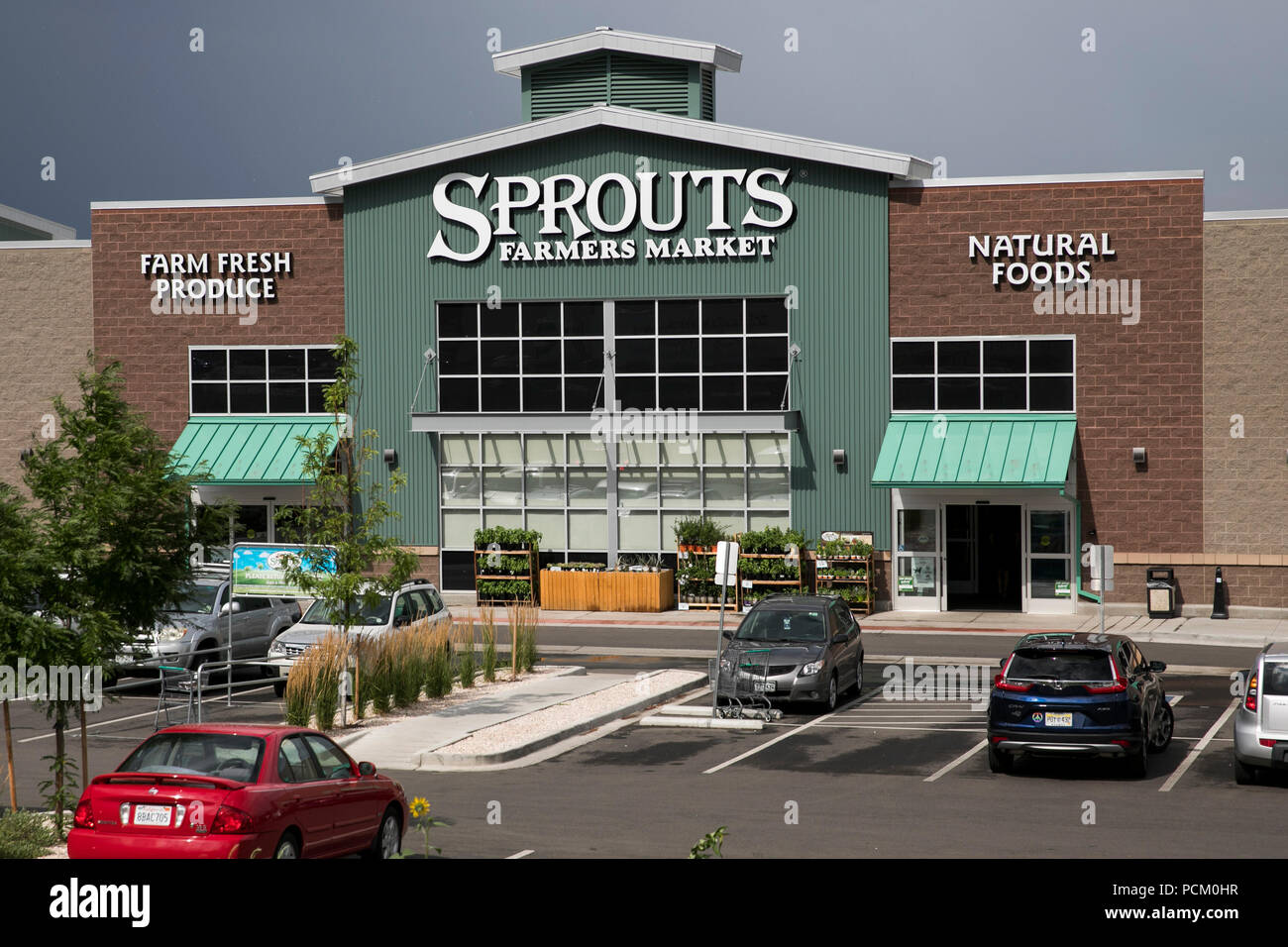 A logo sign outside of Sprouts Farmers Market retail grocery store in