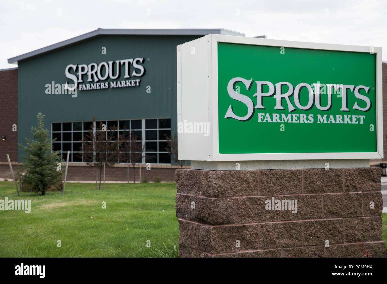 A logo sign outside of Sprouts Farmers Market retail grocery store in