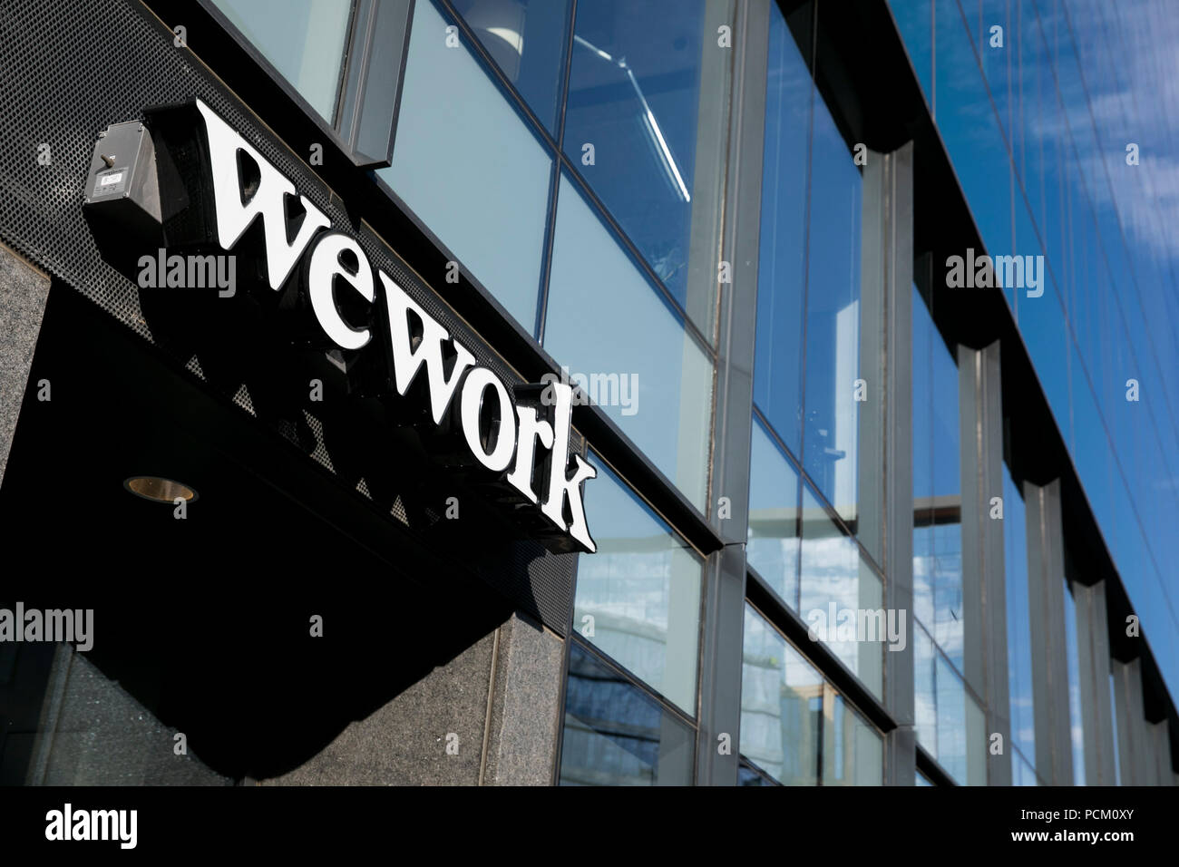 A logo sign outside of a WeWork coworking office location in Denver, Colorado, on July 22, 2018. Stock Photo