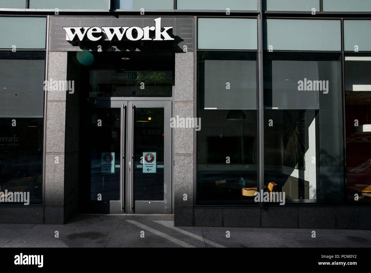 A logo sign outside of a WeWork coworking office location in Denver, Colorado, on July 22, 2018. Stock Photo