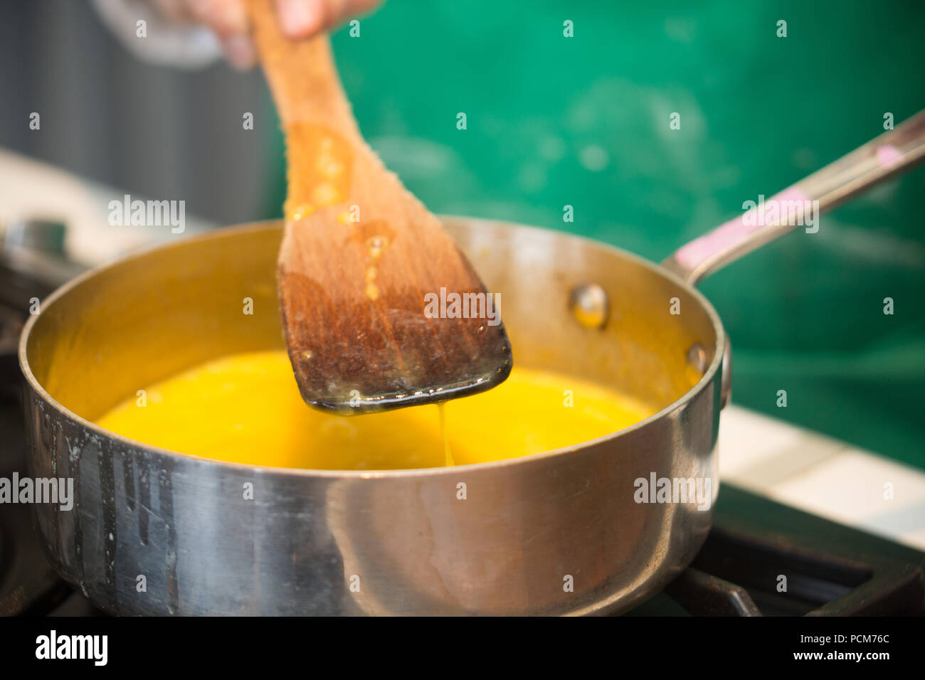 A wooden spatula over a pan of lemon curd on the stove Stock Photo Alamy