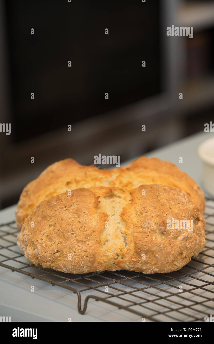 A loaf of crosscut, white Irish soda bread on a wire cooling rack in