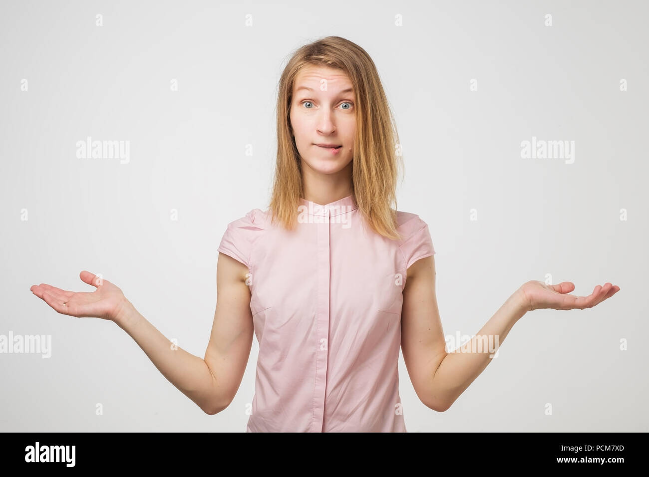 Shrugging european woman wearing pink shirt in doubt doing shrug Stock Photo