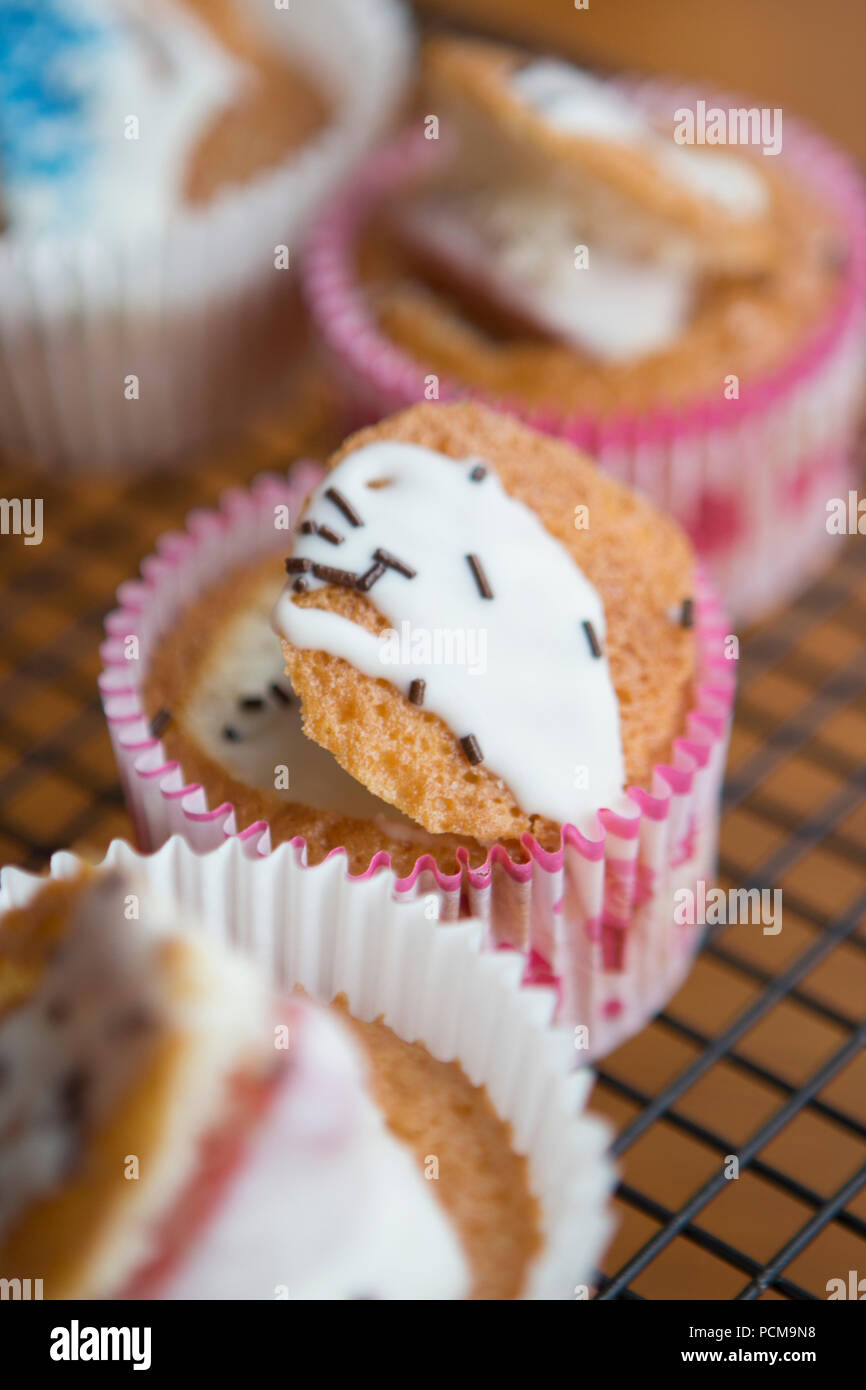 Homemade vanilla cupcakes with a chocolate coated strawberry and icing. Stock Photo