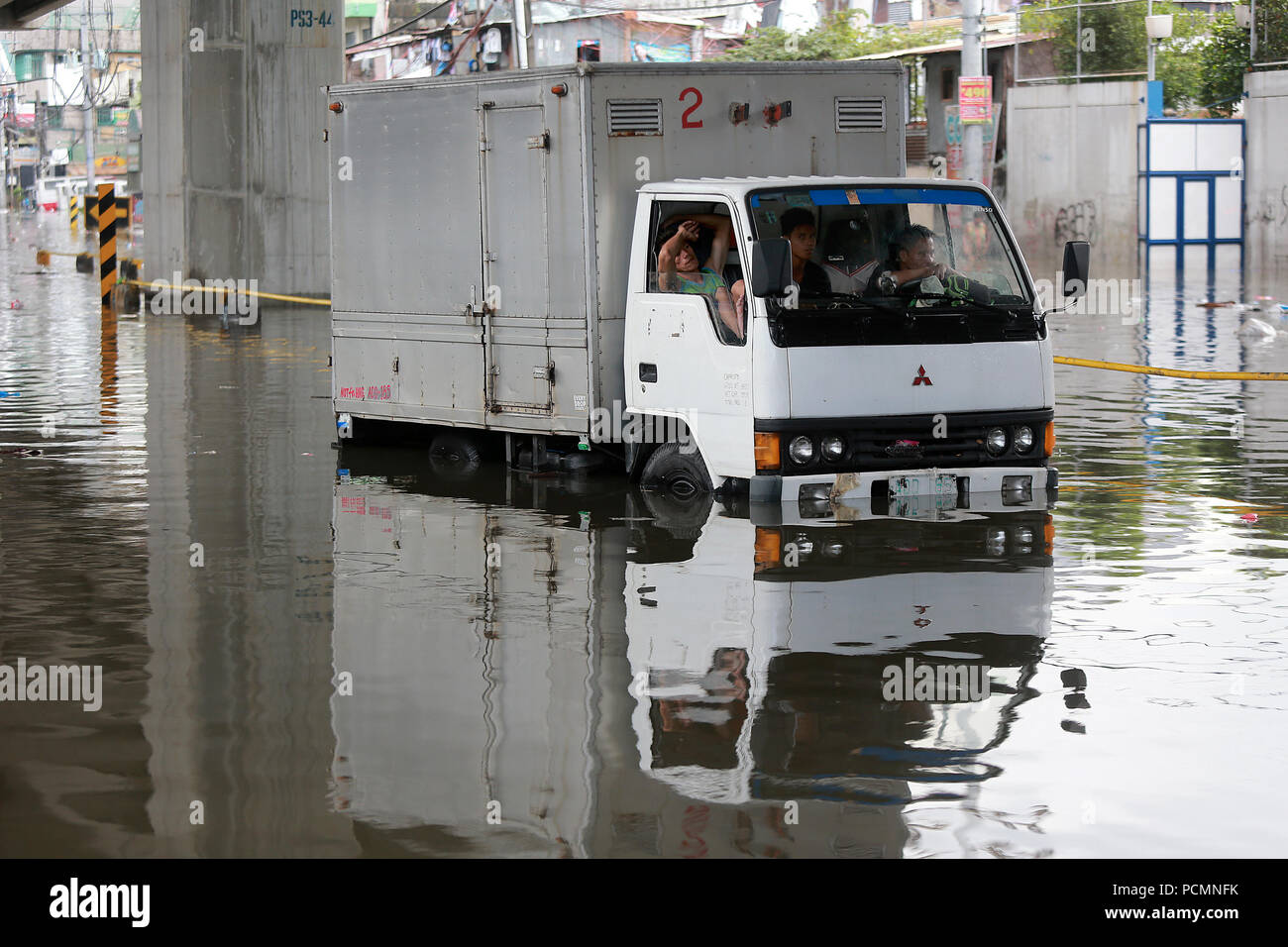 Quezon City, Philippines. 3rd Aug, 2018. A truck is immobilized by the  flood after a heavy monsoon rain in Quezon City, Metro Manila, the  Philippines, Aug. 3, 2018. Several streets and residential