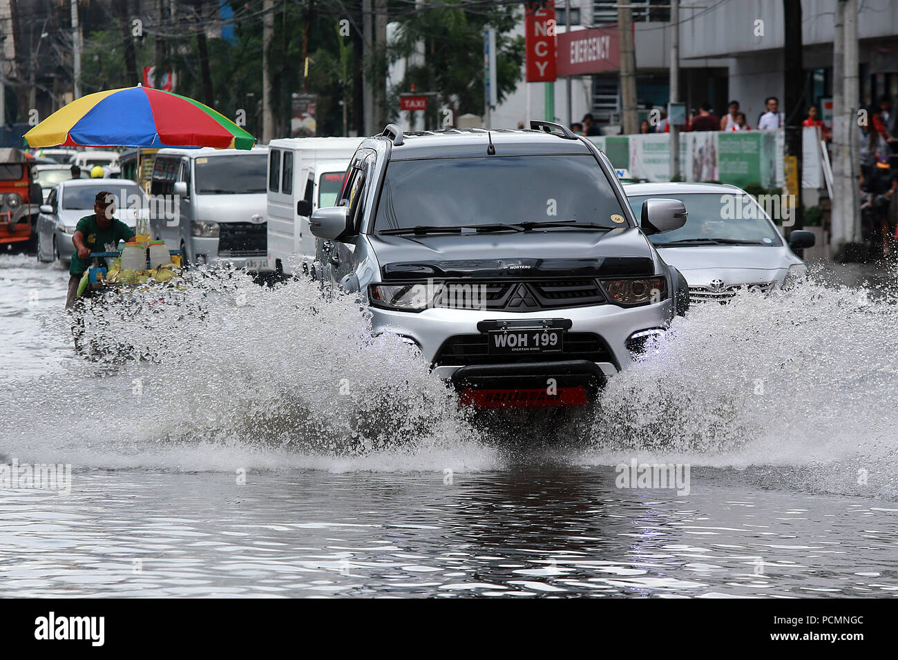 Quezon City, Philippines. 3rd Aug, 2018. Vehicles move along a flooded road  after a heavy monsoon rain in Quezon City, Metro Manila, the Philippines,  Aug. 3, 2018. Several streets and residential areas