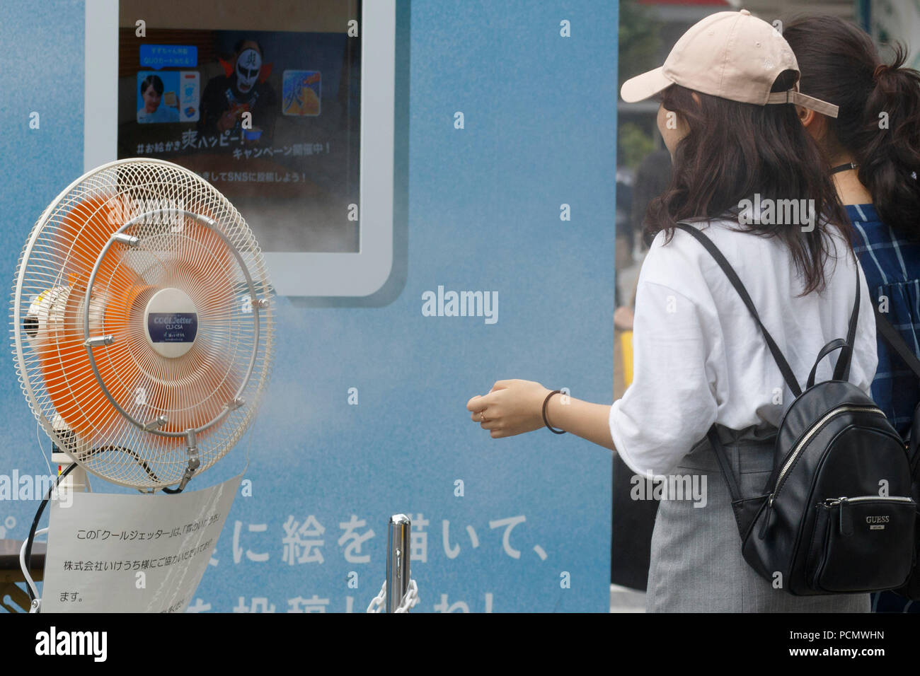 Women stand up in front of a fan to cool themselves off on August 3, 2018, in Tokyo, Japan. Temperatures topped 37 degrees Celsius in Tokyo, on Friday at 2 pm. According to the Tokyo Medical Examiner's Office, ninety-six people died of heatstroke in central Tokyo's 23 wards during the month of July, nearly four times as many as in the same period in 2017. Credit: Rodrigo Reyes Marin/AFLO/Alamy Live News Stock Photo
