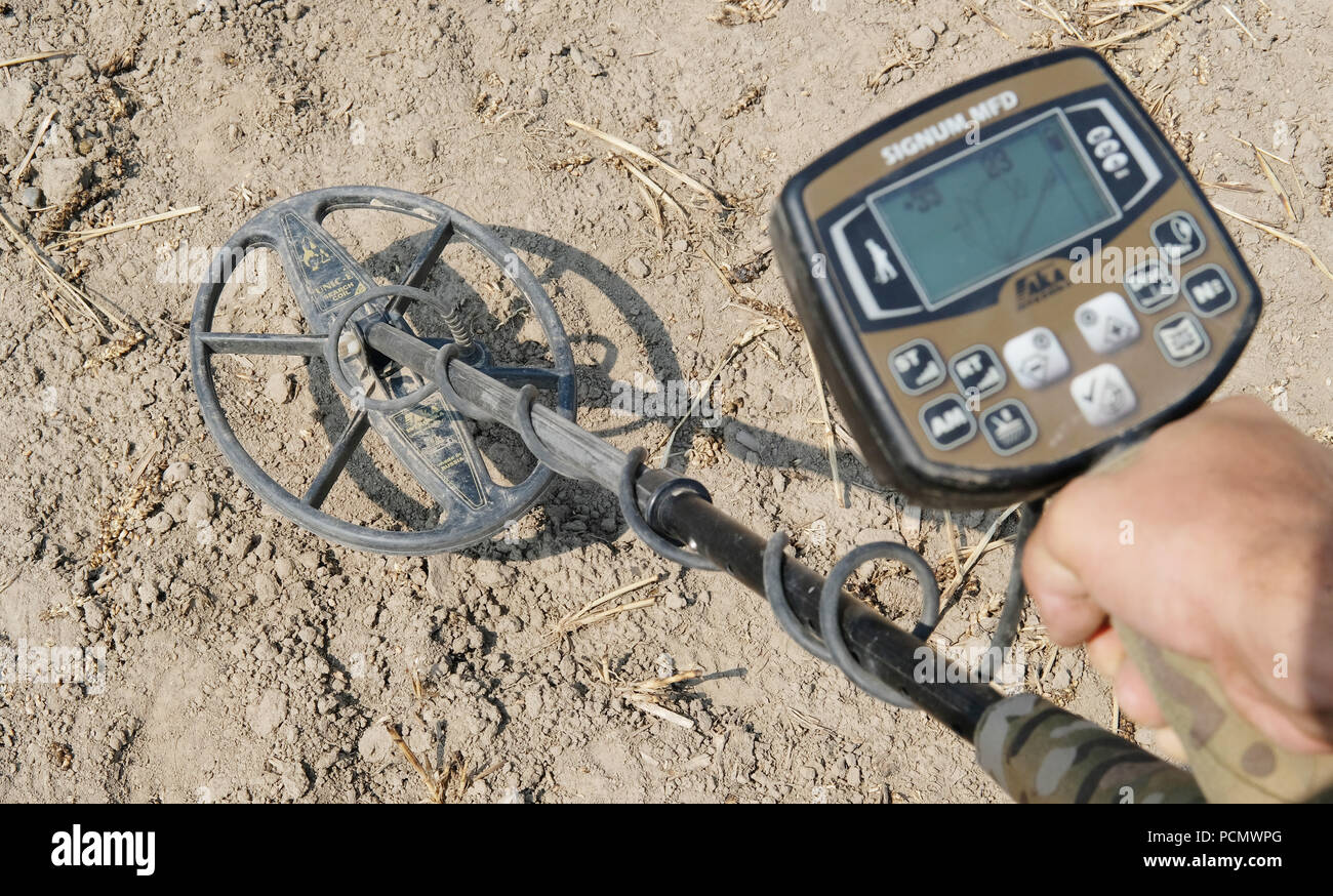 Leipzig, Germany. 03rd Aug, 2018. Michael Schmahl shows a metal detector  over a field in the Leipzig district of Holzhausen. An investigation of the  battlefield of the Battle of the Nations near