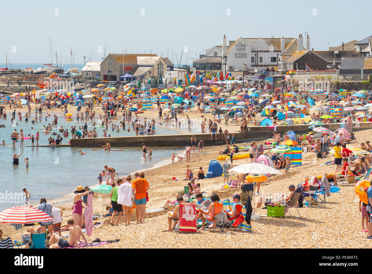 Lyme Regis, Dorset, UK. 3rd August 2018.  UK Weather: Scorching hot sunshine and blue sky in Lyme Regis.  Holidaymakers and sunseekers flock to the packed beach at the seaside resort of Lyme Regis this afternoon as temperatures soar on what is set to be the hottest day on record. Credit: Celia McMahon/Alamy Live News Stock Photo