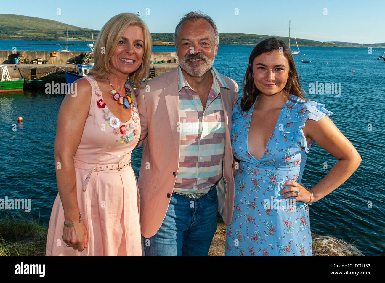 Ahakista, West Cork, Ireland. 3rd Aug, 2018.  As part of the Ahakista August Festival, Graham Norton hosts the Annual Graham Norton Table Quiz.  Special guest, Jennifer Barry (from the Young Offenders), also attended the festival. Graham and Jennifer are pictured with Eilis Hodnett, Festival Chairperson. The proceeds of the quiz are going to the Ahakista Community Association.  Credit: Andy Gibson/Alamy Live News. Stock Photo