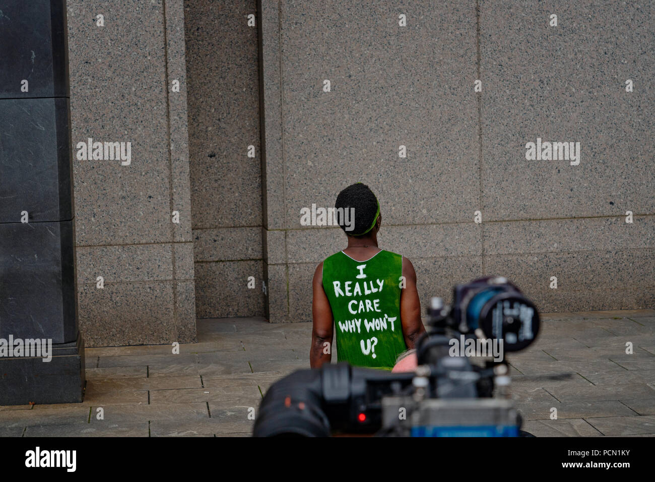 New York, New York, U.S., 3 August 2018  Immigration activist Therese Patricia Okoumou speaks outside federal court in Manhattan after hearing on trespassing & disorderly conduct charges.  Okoumou, a native of Congo, scaled the base of the Statue of Liberty on July 4, 2018, to protest against Trump administration immigration policies.  Okoumou wore a green dress to court bearing the words “I really care why won’t u?” – a response to first lady Melania Trump, who wore a jacket with the words “I really don’t care, do u?” when she visited a facility for migrant children in June. Stock Photo