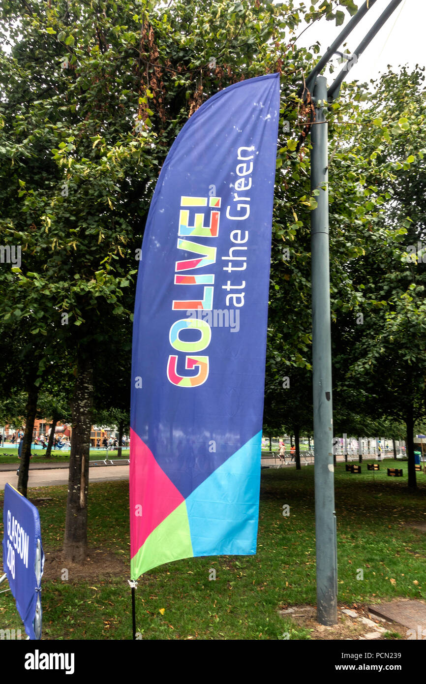 Glasgow Green, Glasgow; Scotland. 03rd August 2018. A feather banner and a sign at the entrance of Go Live! at the Green, part of Festival 2018. The festival is running in parallel with the European Championships; Glasgow 2018. Glasgow Green is a free festival venue with many attractions from give-it-a-go sports to music and cooking demonstrations. Credit: Elizabeth Leyden/Alamy Live News Stock Photo