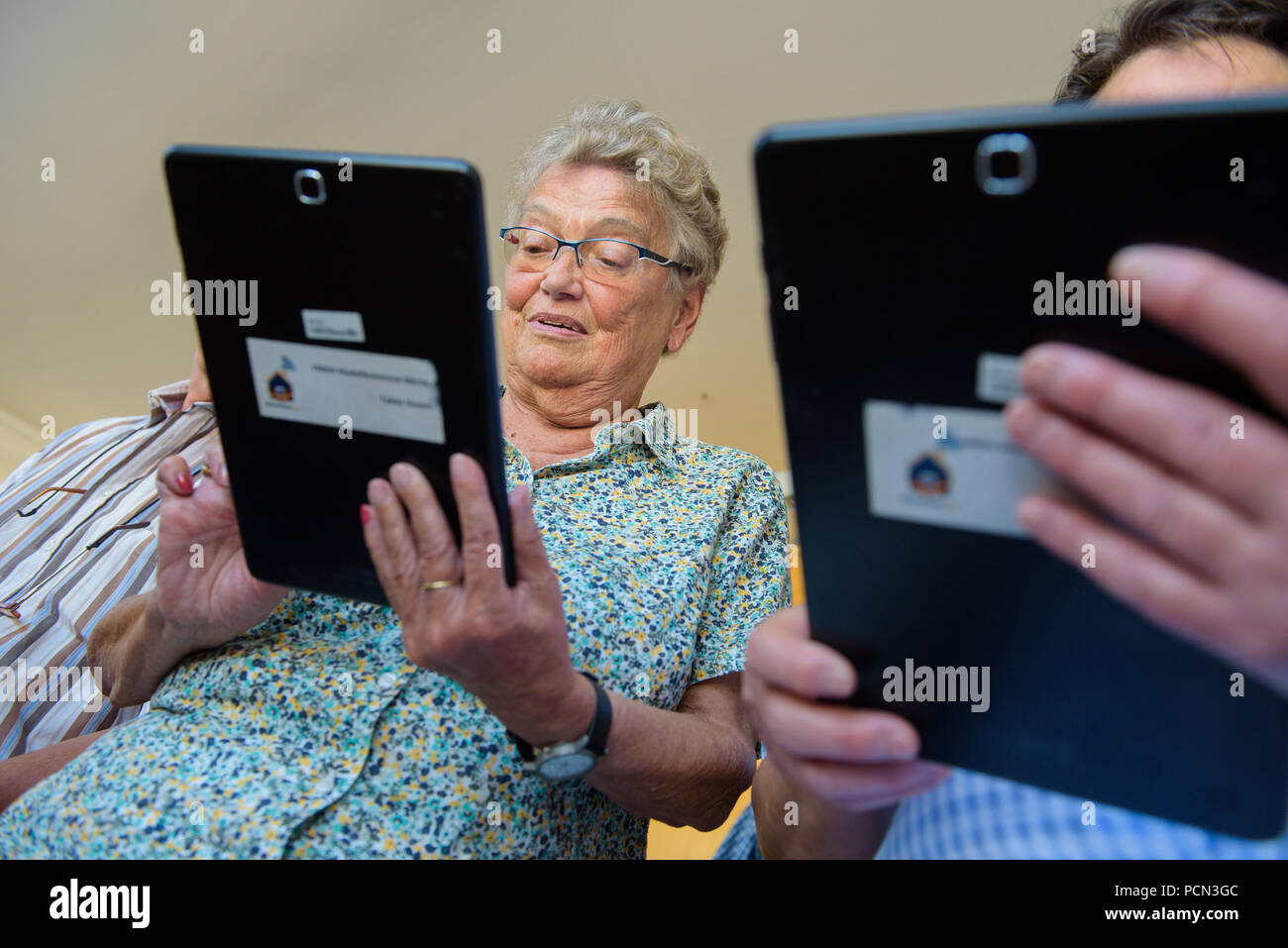 Schwalbach, Germany. 02nd Aug, 2018. Participants in the 'Virtual Multi-Generational House' project hold tablets in their hands. In this project, people learn how to use tablets so that they can network with each other across generations. (on dpa lrs-Korr: 'Virtual project networks generations in Saarland' of 04.08.2018) Credit: Oliver Dietze/dpa/Alamy Live News Stock Photo