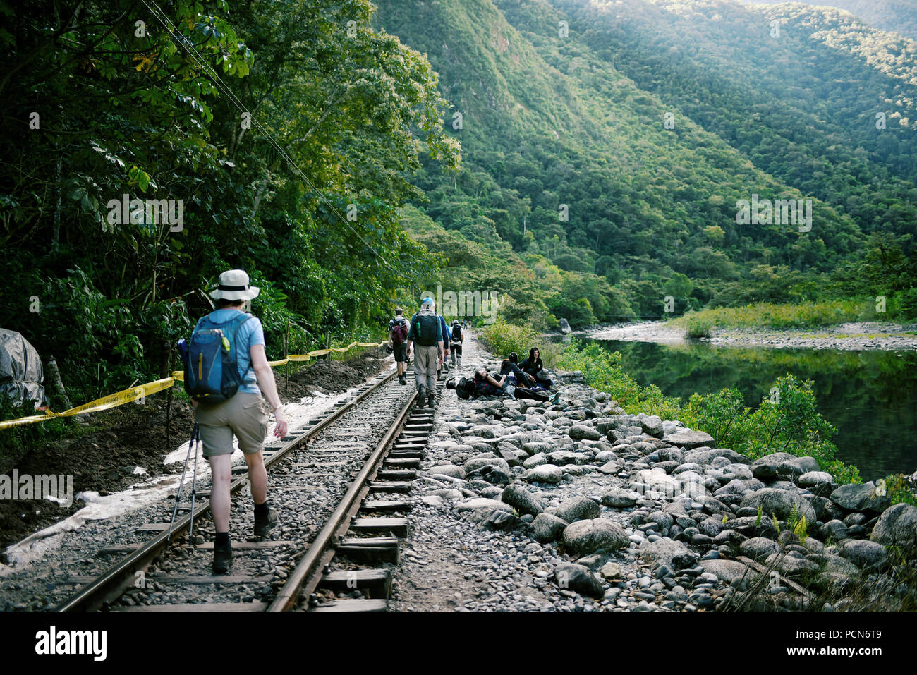Tourists walking along the railway tracks from Hidroelectrica to Aguas Calientes, Peru. The 2.5 hrs walk (12km) is full of amazing scenery. Jun 2018 Stock Photo
