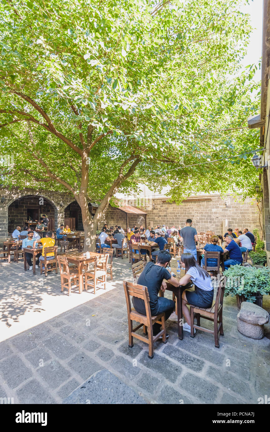 Unidentified people sit courtyard of Suluklu Khan,a medieval inn used for cafes and small shops now in Diyarbakir,Turkey.16 July 2018 Stock Photo