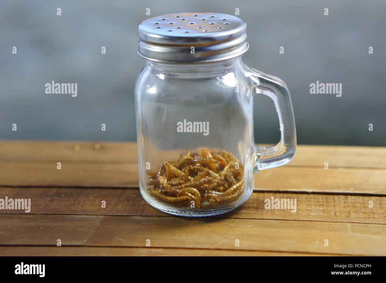 Roasted beetle larvae in a jar at sunset Stock Photo