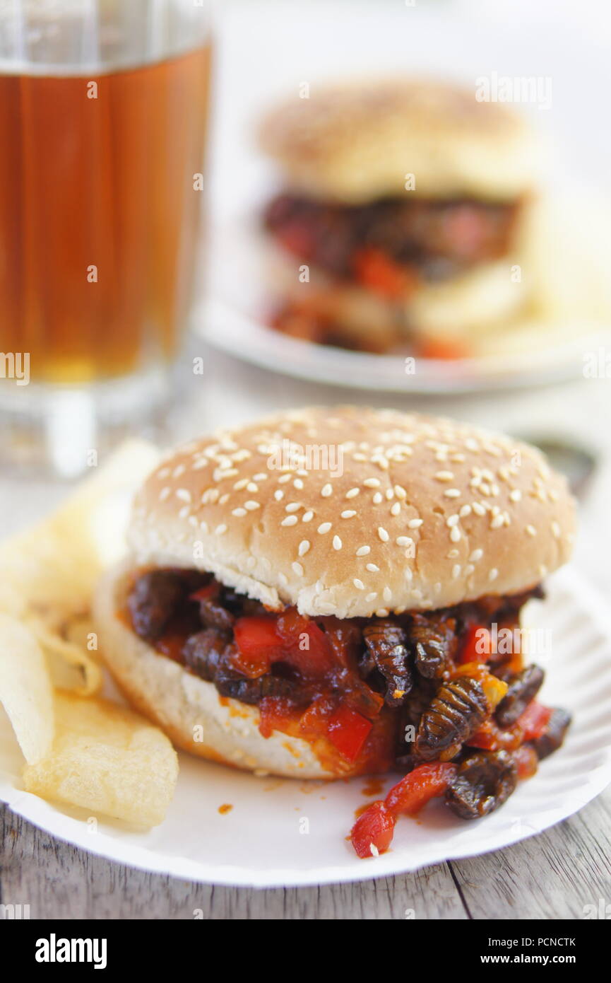 Silkworms with ketchup, mustard, peppers, tomatoes, prepared in the style of a classic sloppy joe. Stock Photo