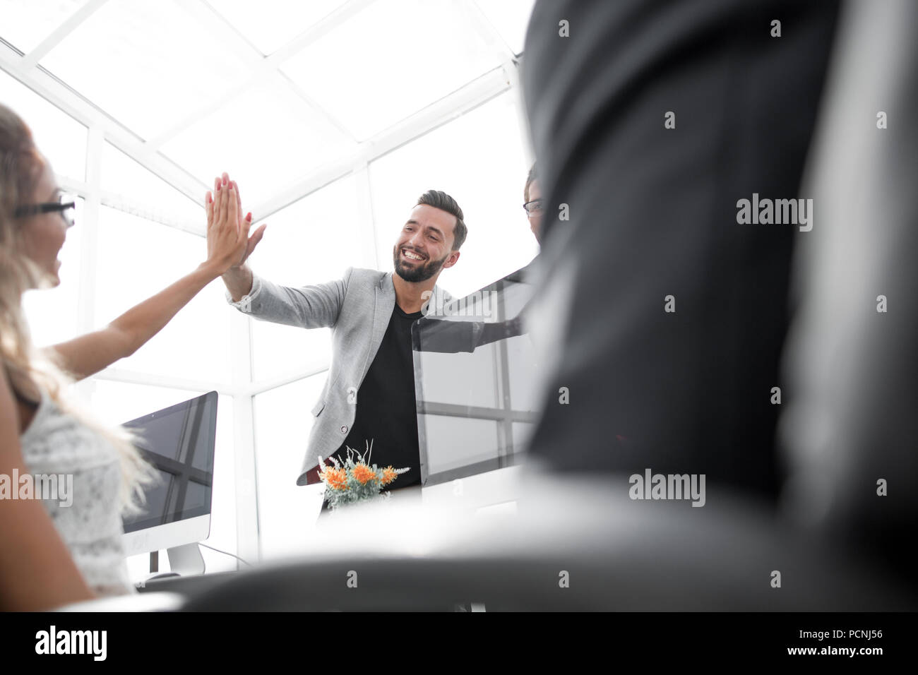 young employees giving each other high five Stock Photo - Alamy