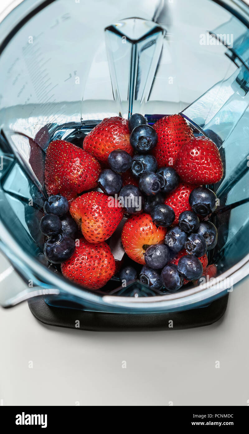 Strawberry and blueberries in blender with ingridients for smoot Stock