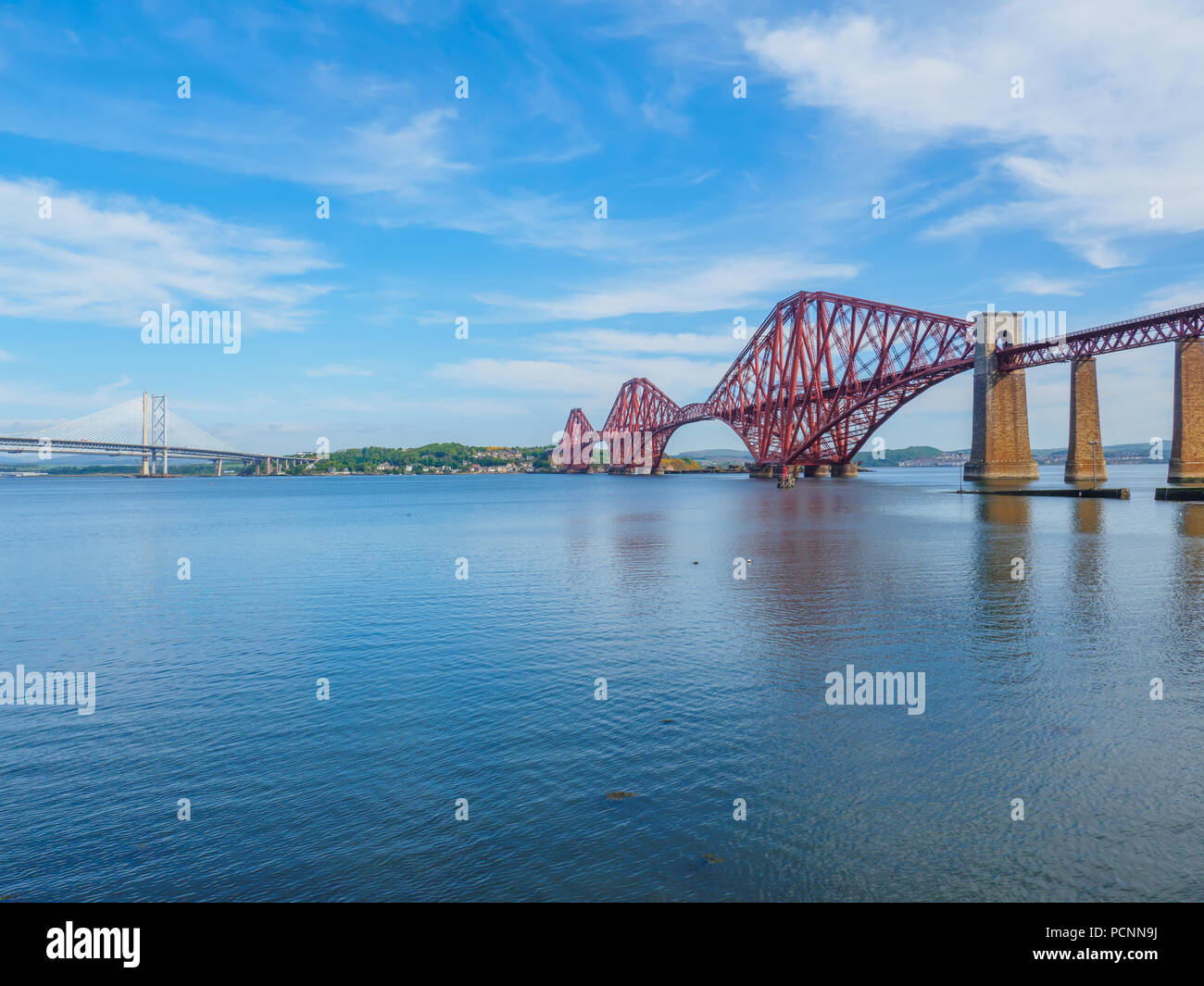 View of the iconic Forth Rail Bridge over the Firth of Forth (on the right) with the older Forth Road bridge (on the left) and new Queensferry Crossin Stock Photo
