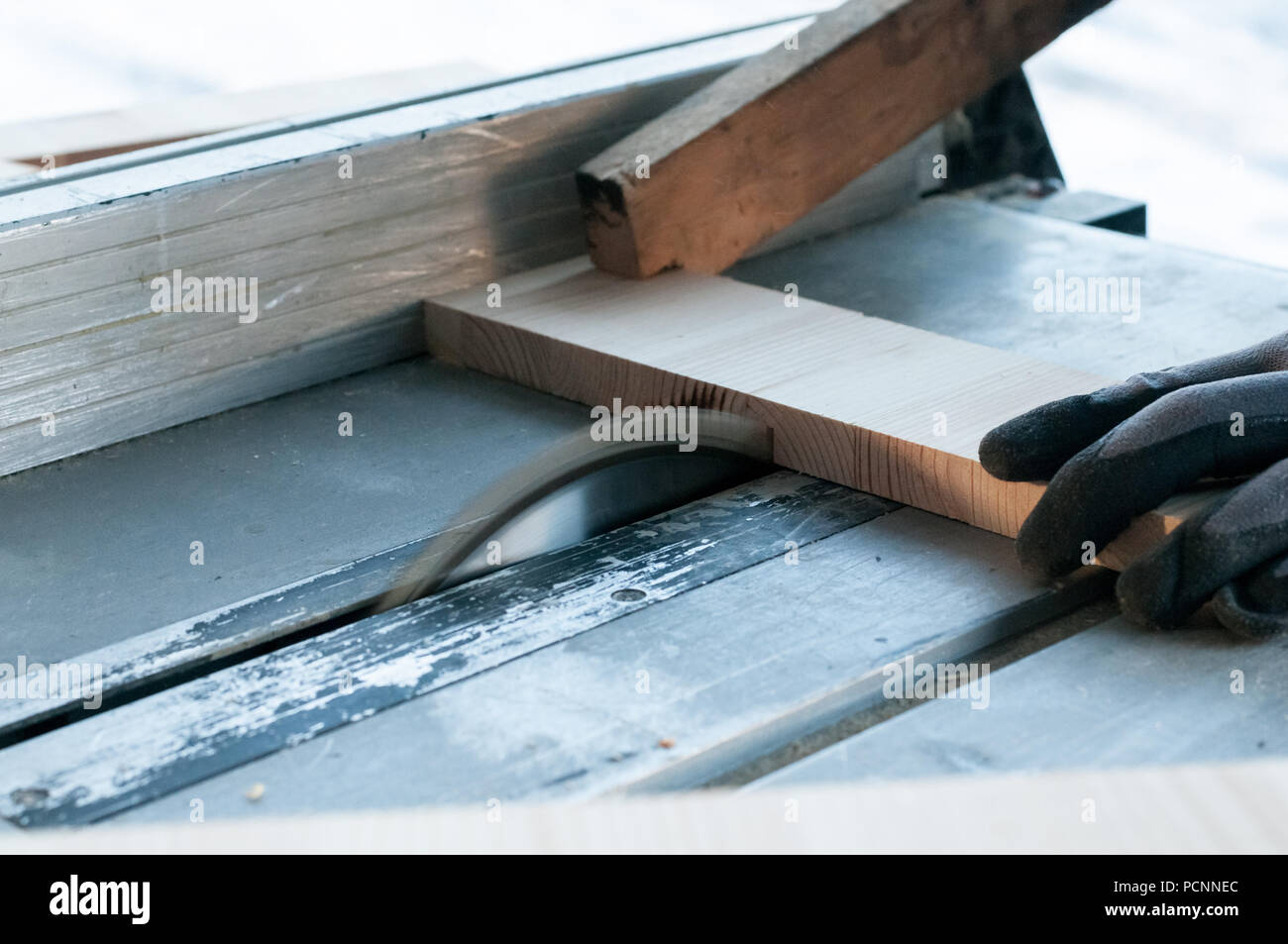An action shot of a carpenter cutting wood using a wood cutting blade Stock Photo