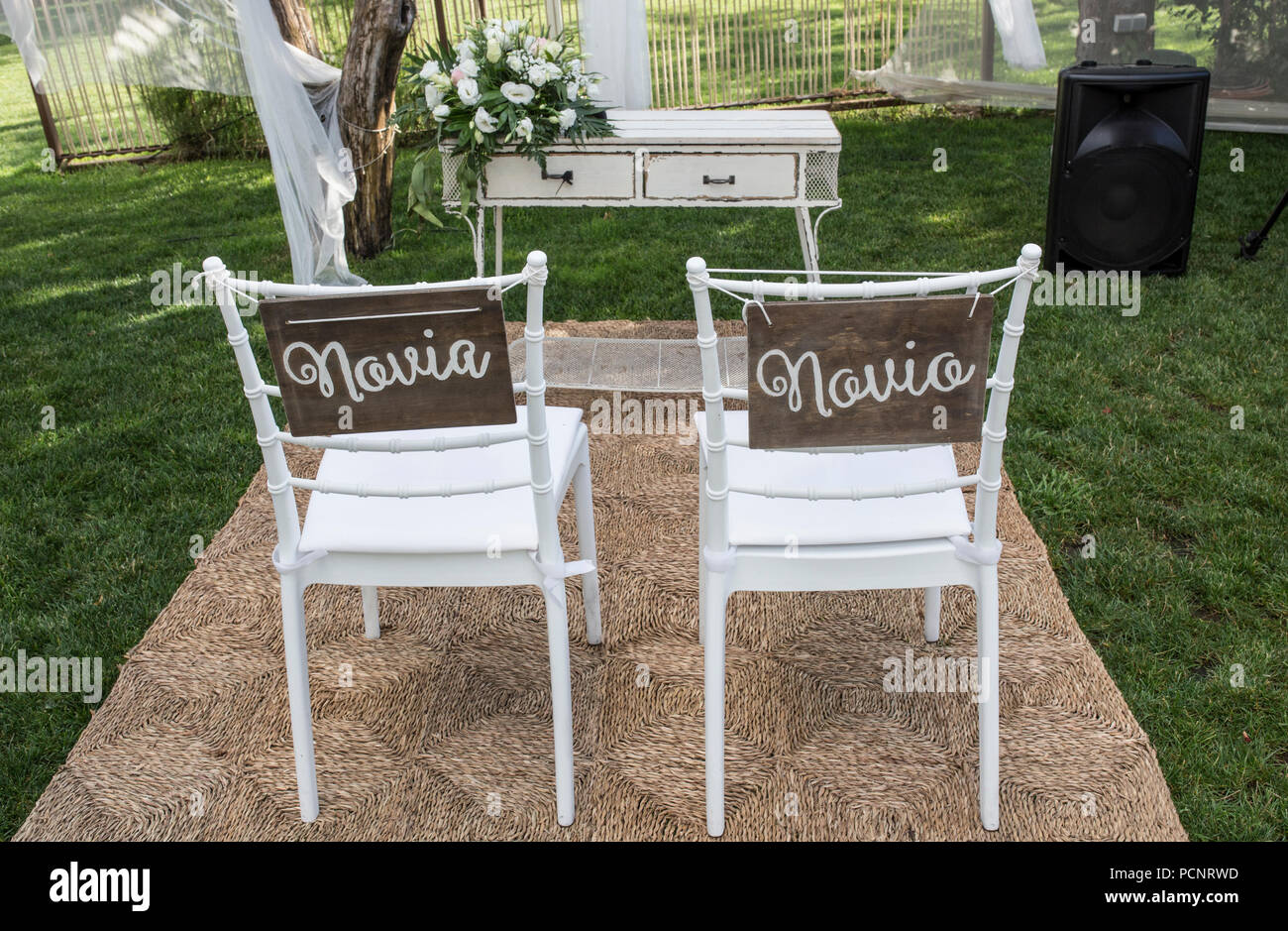 Chairs for bride and groom at altar. Spanish sign Novia y Novio Stock Photo
