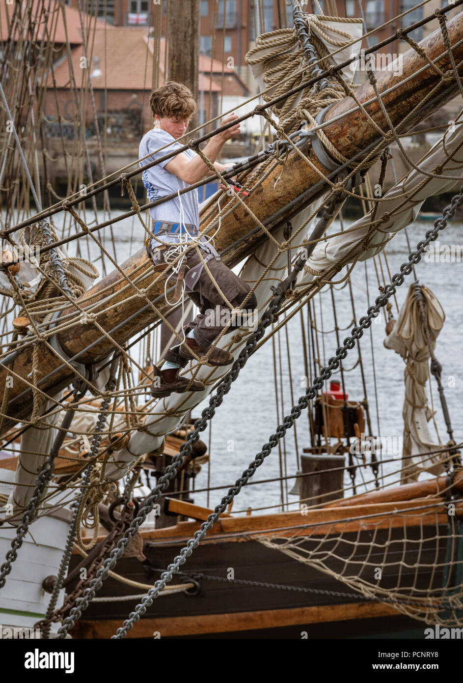 Sailor working on the rigging of a sailing ship in harbour during the 2018 Tall Ships Race Stock