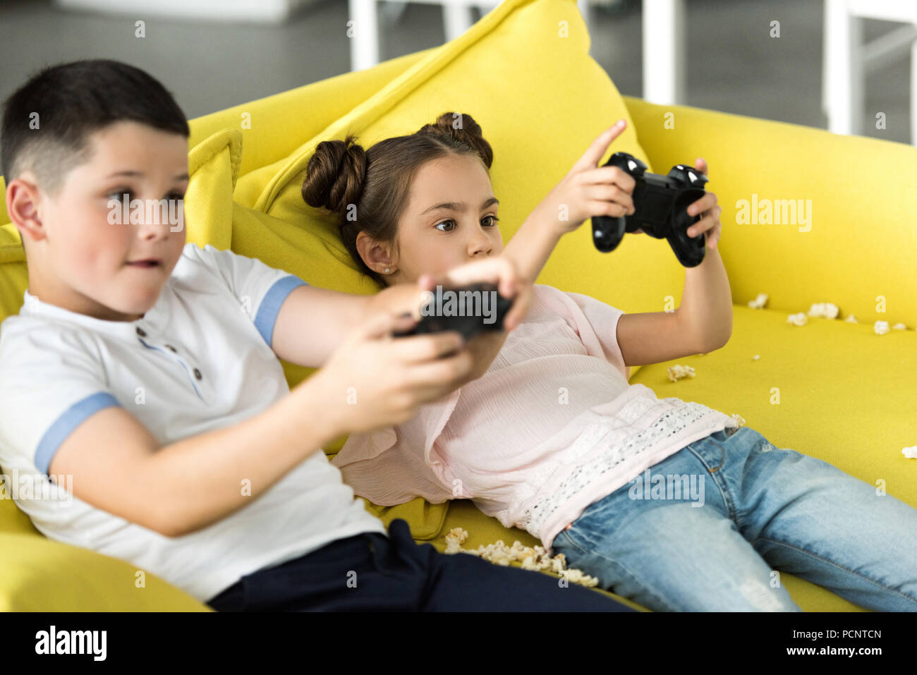 serious sister and brother playing video game at home Stock Photo