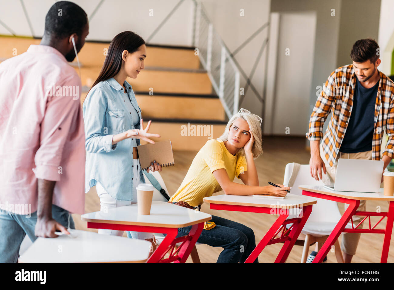 multiethnic young students spending time together in lecture room of college Stock Photo