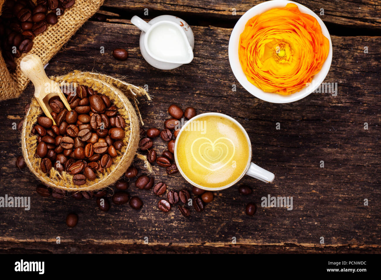Espresso with heart,milk jug,fresh roasted coffee beans and blossom