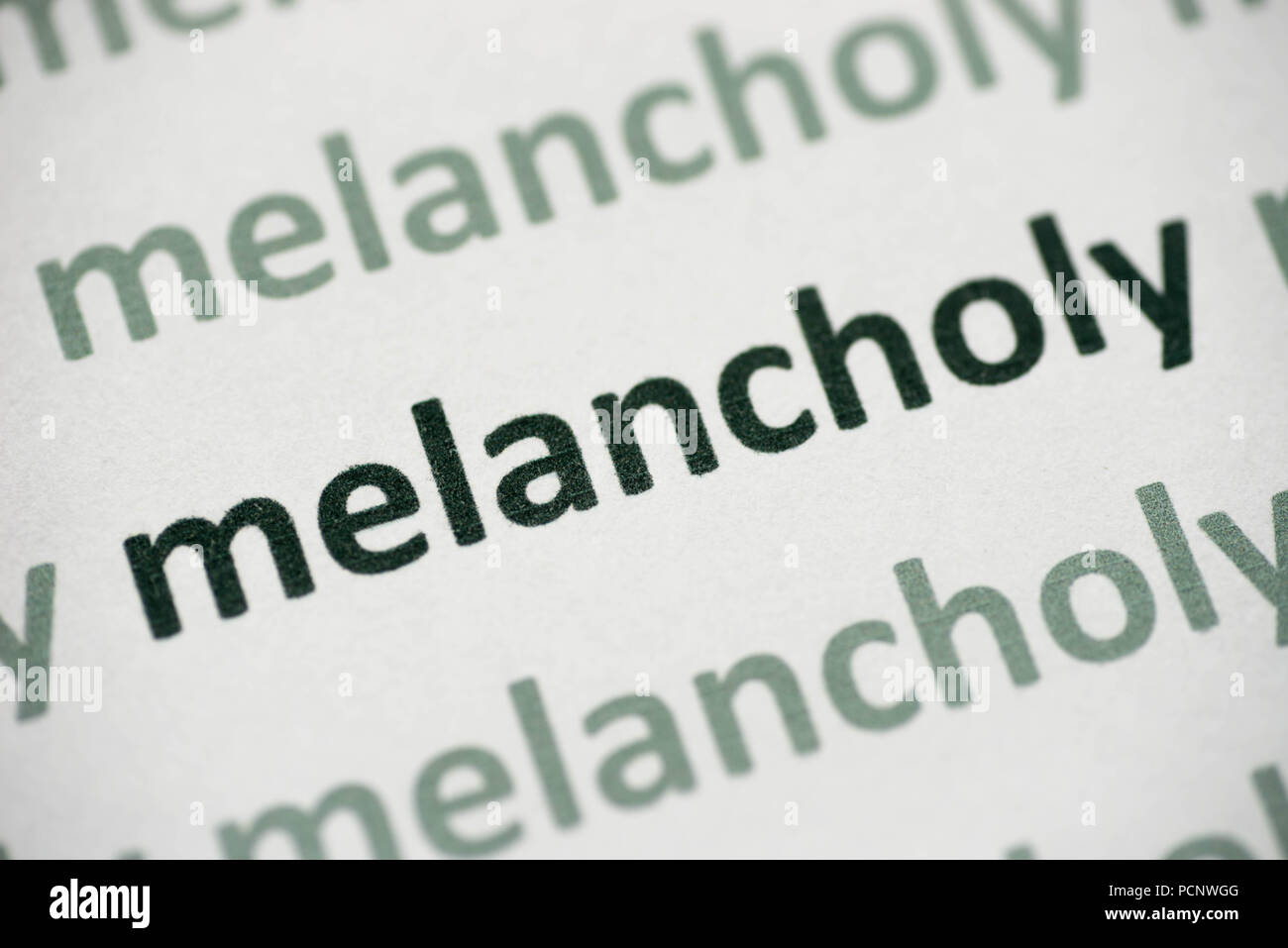 word melancholy printed on white paper macro Stock Photo