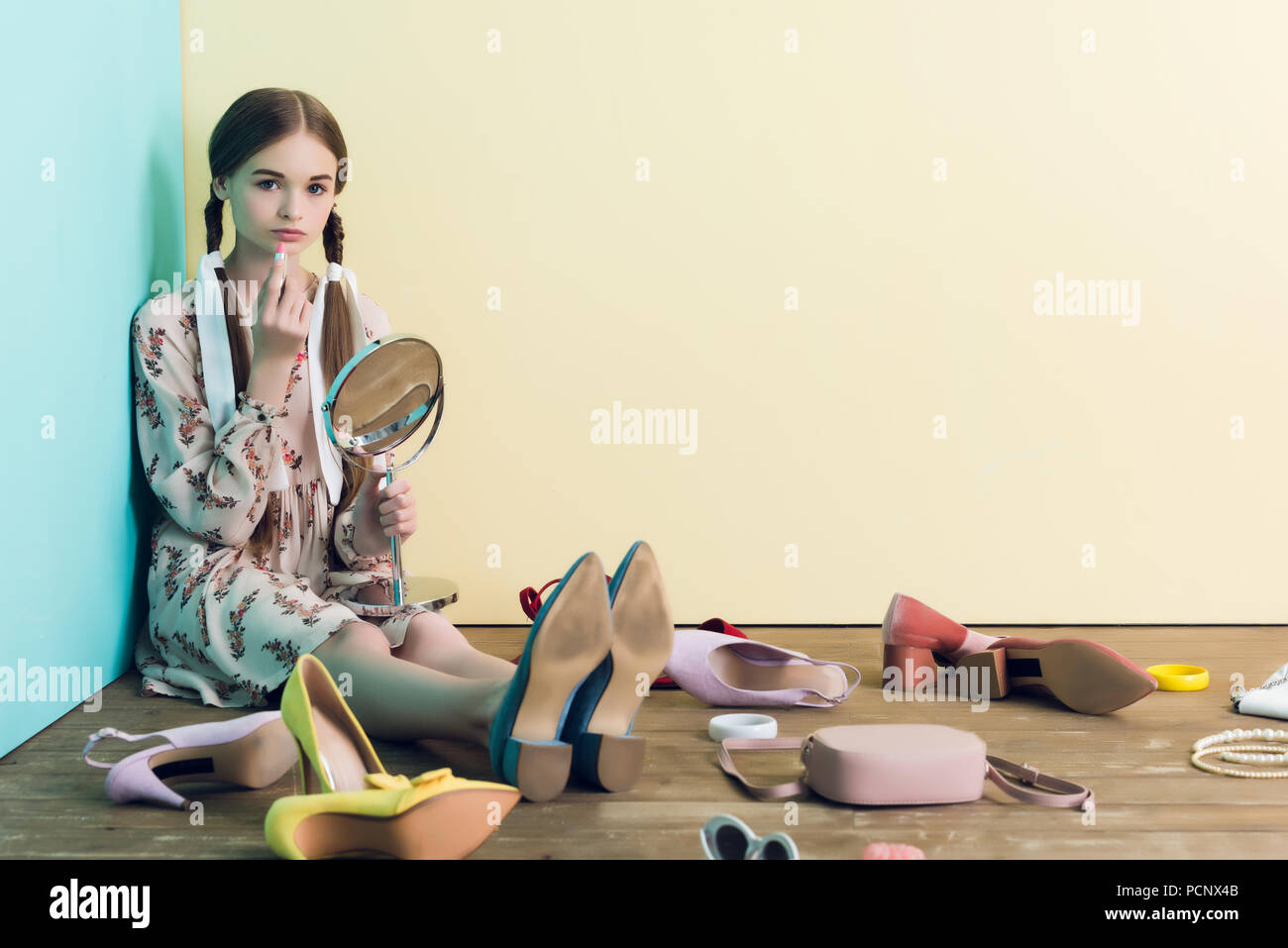 teen mirror shots beautiful teen girl applying makeup with mirror while sitting on floor with  mess Stock Photo - Alamy