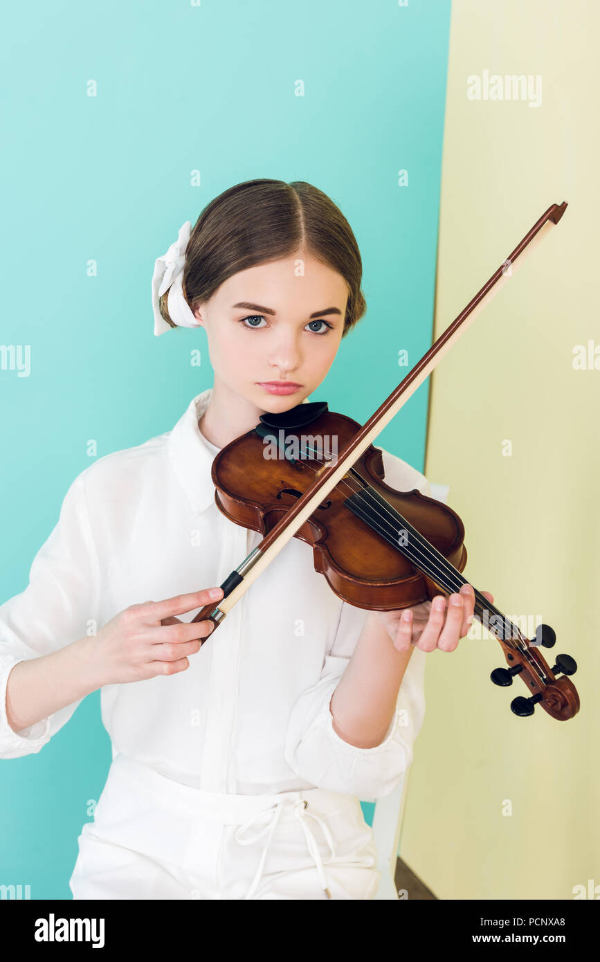 teen girl in trendy white outfit playing violin Stock Photo - Alamy