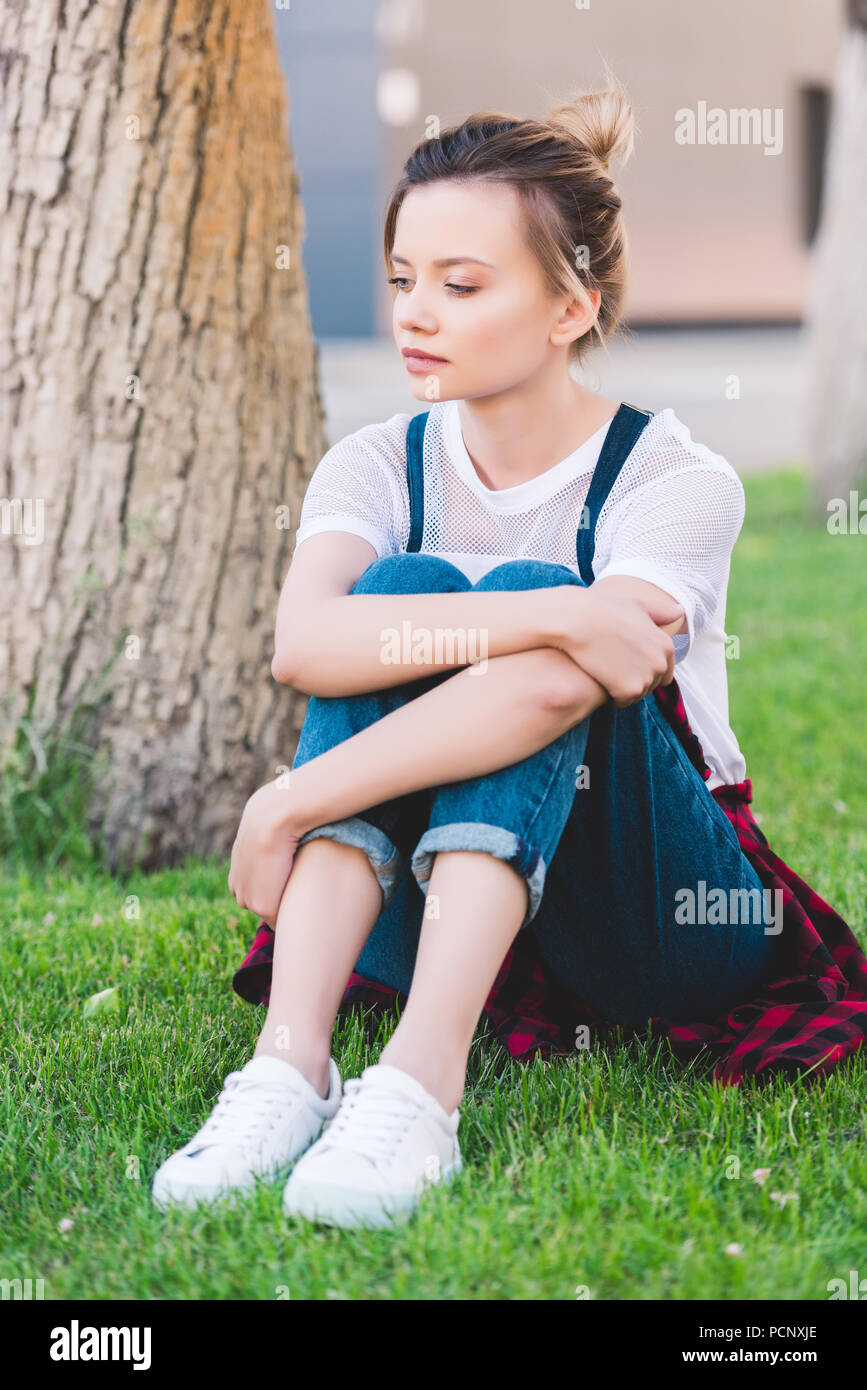 Sad girl sitting in grass hi-res stock photography and images - Alamy