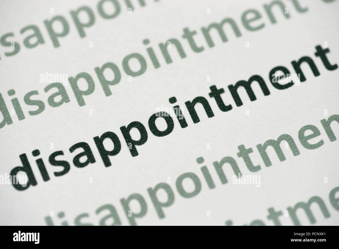 word disappointment printed on white paper macro Stock Photo