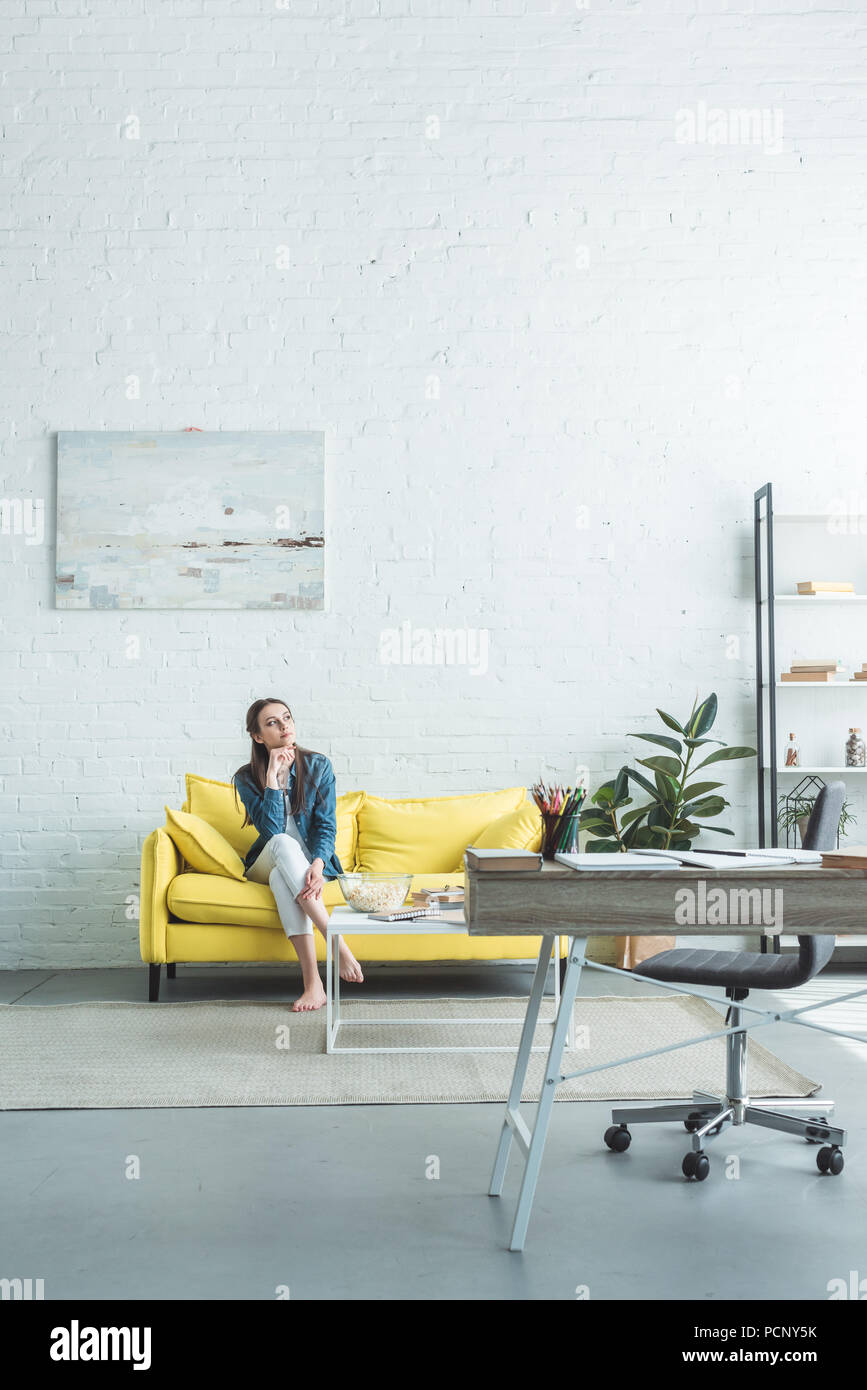 Girl sitting barefoot on sofa hi-res stock photography and images - Alamy