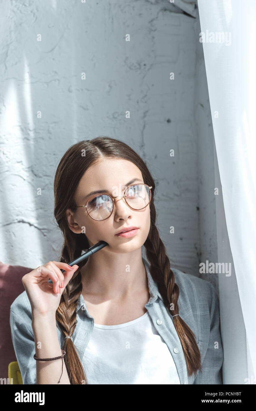 beautiful thoughtful teen girl with braids in eyeglasses Stock Photo